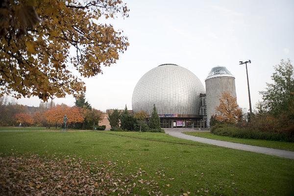 View across a green lawn of the silver dome of the Zeiss Planetarium, an astronomical obervatory in Berlin, Germany