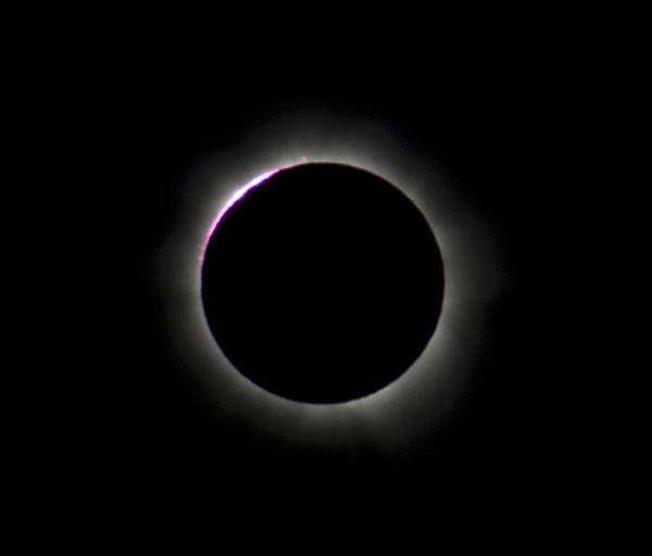 Prominences ejecting from the suns surface can be seen along the edge of the moons shadow during a total solar eclipse