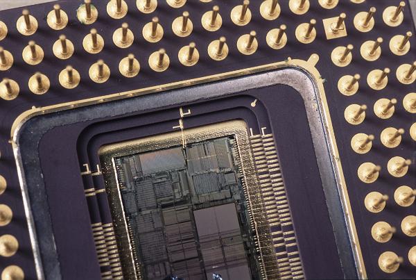 cutaway section showing the inside of a microprocessor chip. the silicone wafer of the chip show visible patterns outlining tarious arrays of memory, registers and other circuits used in the CPU