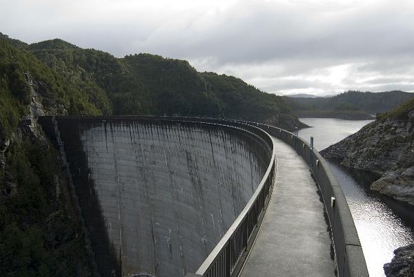 a view from the footpath along to top of the gordon river dam, tasmania, the curve on the dam wall distributes the force of the water behind the dam sideways into the canyon wall