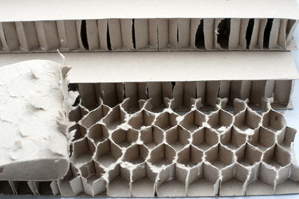 a cardboard lattice, think sheets of card formed into hexagonable shapes and glued between further layers of card produce a strong boardlike material