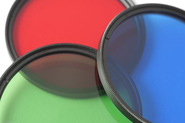 Set of three circular red, green and blue primary glass filters arranged to overlap, closeup detail