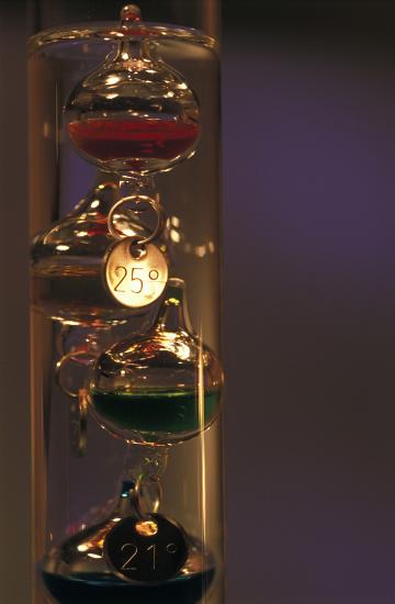 a galilean thermometer contains floating or sinking glass vessels containing different densites of liquid that rise and sink as the termperature changes