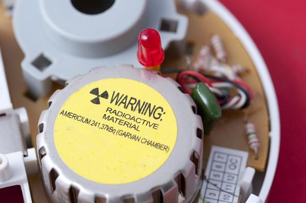 Inside an ionising smoke alarm. The sealed detector cell contains a radioactive source, emissions from which are 'mopped up' by any smoke particles entering the chamber, the fall in detected emissions triggers the alarm