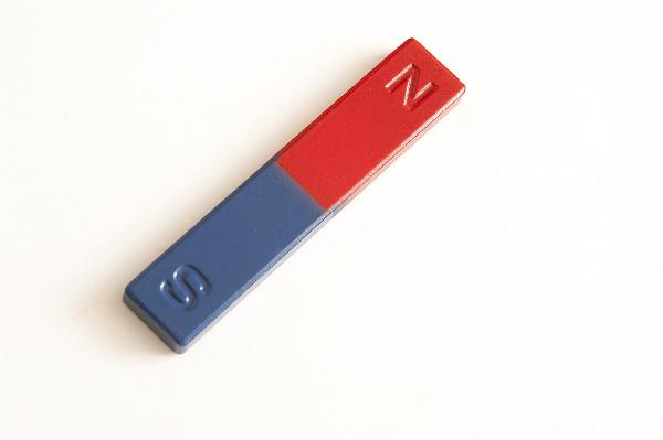 A close up of a red and blue bar magnet on a white background with copy space.