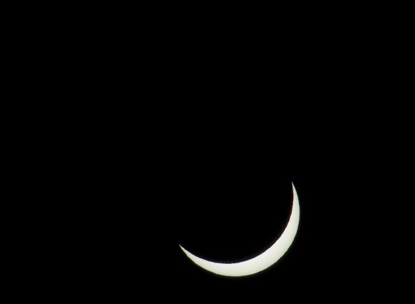 penumbra stage of a solar eclipse, with the moon almost covering the sun leavng only a narrow crescent