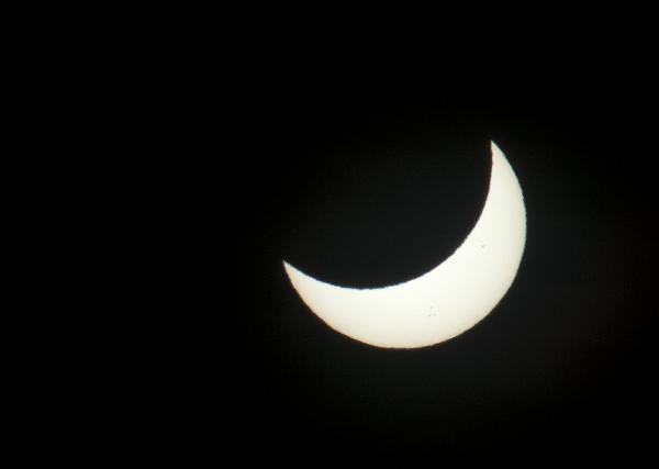 The sun as pictured through a dark filter during a solar eclipse, partially blocked by the moon
