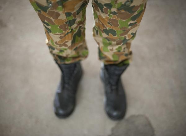 looking down at a soldier wearing army green camoflage pants, the disruptive pattern material is special designed to blend in with a range of background terrains and prevent the solder from being detected