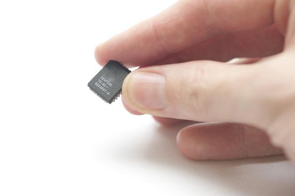 Small Chip in Fingertips on white background. this chip was used to store firmware an embeddeed computer application