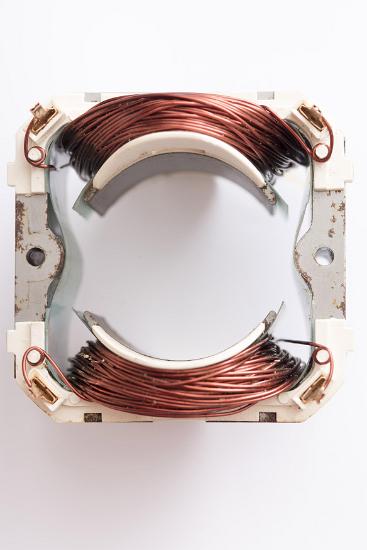 Close up of electric motor stator with copy space A close up of an electric motor stator on a white background with copy space.
