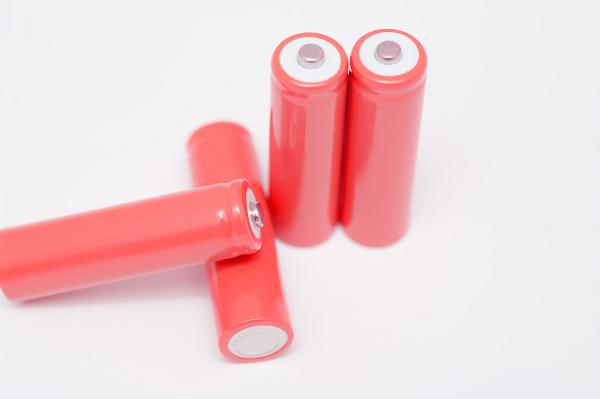Set of four unbranded pink batteries with two upright and two displayed to show the positive and negative terminals on a white background