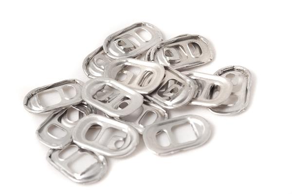 Small pile of opening ring pulls from beverage cans manuractured from titanium, viewed in close-up and isolated on white background