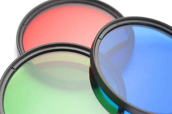 Set of circular filters showing the primary colors red, green and blue arranged to overlap on a white background, close up view