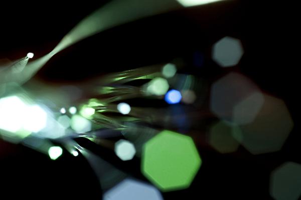 Optical fiber close up with bokeh on black background, concept of physics, light and space